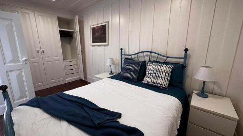 Un dormitorio con una cama azul y blanca con almohadas en Palheiro da Ana en Costa Nova