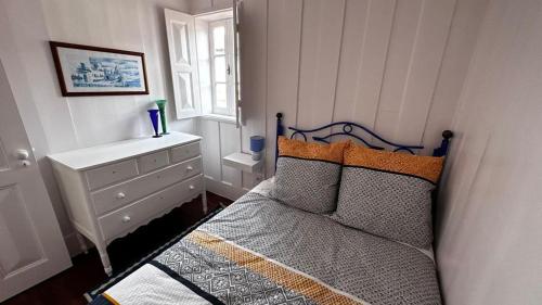 a bedroom with a bed with a dresser and a window at Palheiro da Ana in Costa Nova