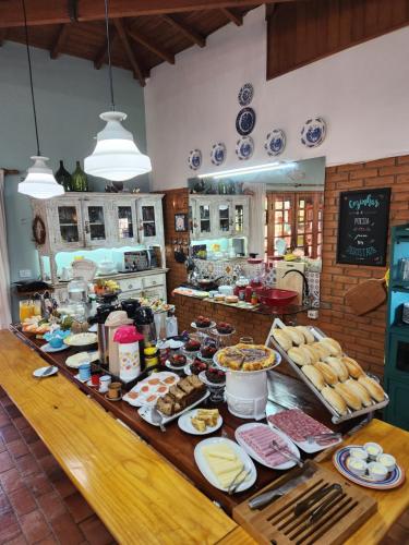 a kitchen with a table with food on it at Pousada Vale Monte Azul in Santo Antônio do Pinhal