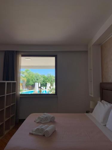 a bedroom with two towels on a bed with a window at Carone Suite-Charme&Pool in Polignano a Mare