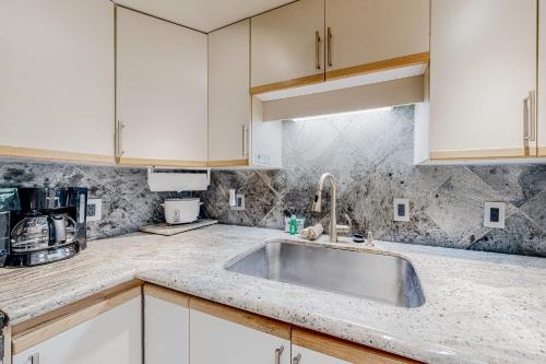 a kitchen with white cabinets and a sink at Maui Banyan B204 in Wailea
