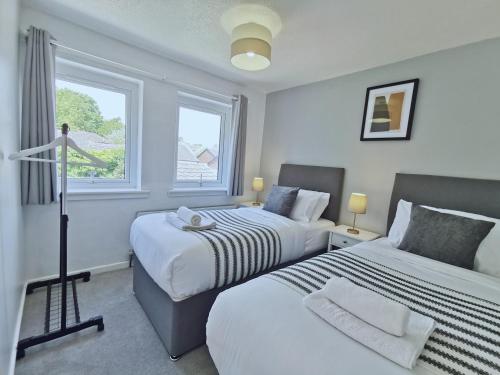 um quarto com 2 camas e 2 janelas em Dawley Detached House 3 Bedrooms with parking, garden, Wi-Fi em Dawley