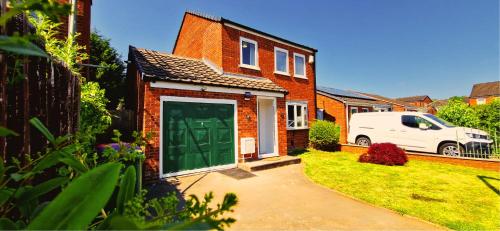 a brick house with a green door in a yard at Dawley Detached House 3 Bedrooms with parking, garden, Wi-Fi in Dawley