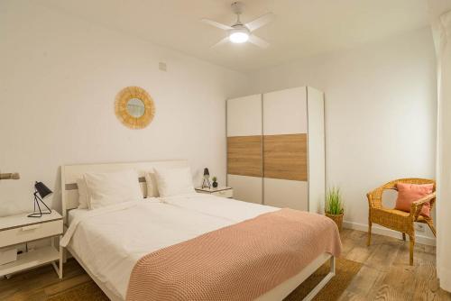 a white bedroom with a bed and a chair at Modern brand new Apartment Torrevieja Centre 2 in Torrevieja