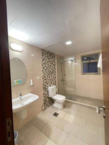a bathroom with a toilet and a sink and a shower at سافانا امواج Amwaj savana in Half Moon Bay