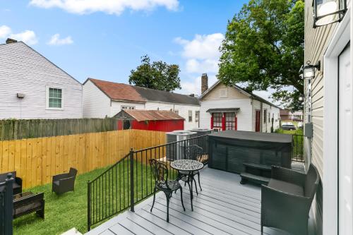 a deck with a table and chairs and a fence at New Luxury 3BR w Jacuzzi in New Orleans