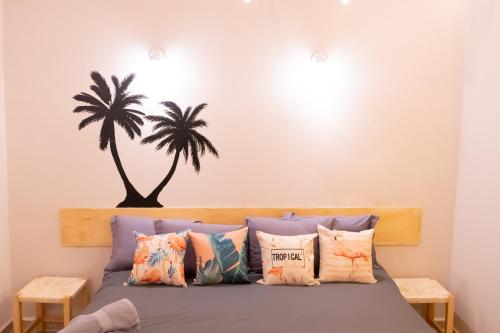 a bedroom with a bed with a palm tree on the wall at ONCE UPON A TIME IN MEXICO - KASA KAKTUS in Mexico City