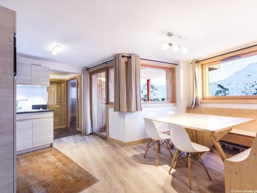 une cuisine et une salle à manger avec une table et des chaises dans l'établissement Magnifique 4 pièces avec piscine, jacuzzi, et cheminée à Avoriaz - FR-1-314-133, à Avoriaz