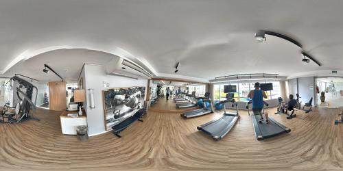 a gym with treadmills and people on treadleys at Apart-hotel TrueAmérica in Campos dos Goytacazes