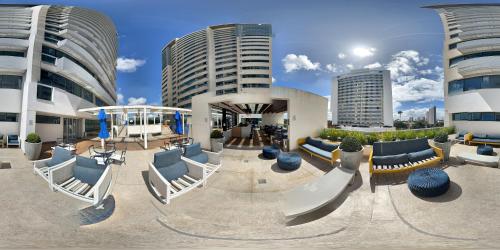 ein Gebäude mit Stühlen und Tischen und Gebäuden in der Unterkunft Apart-hotel TrueAmérica in Campos dos Goytacazes