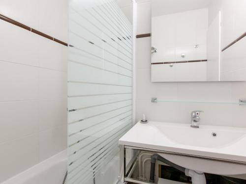 une salle de bain blanche avec un lavabo et un miroir dans l'établissement Appartement cosy 6 pers, balcon sud, centre d'Avoriaz, TV, WiFi, accès direct pistes et commerces. - FR-1-314-157, à Avoriaz