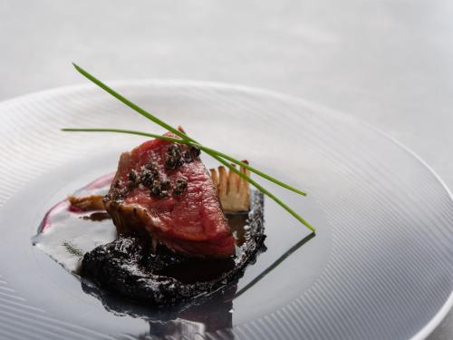 a piece of meat on a white plate at Bettei Amafuru Oka in Ibusuki