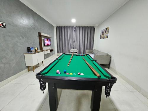 Casa do Sonho, Piscina, Sinuca, Churrasqueira في مارينجا: غرفة معيشة مع طاولة بلياردو وأريكة