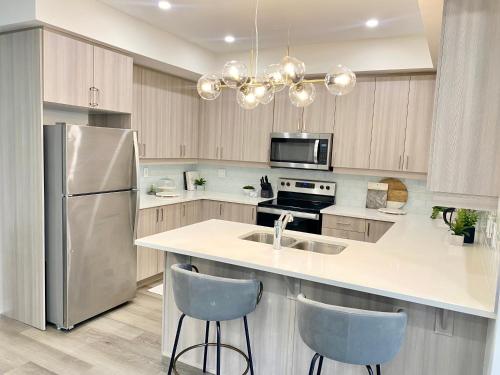 a kitchen with a sink and a refrigerator at Modern and Bright Luxury Home Centrally Located in Toronto’s GTA in Toronto