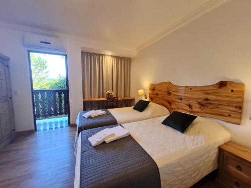 2 łóżka w pokoju hotelowym z oknem w obiekcie Hotel Schneider w mieście Treze Tílias
