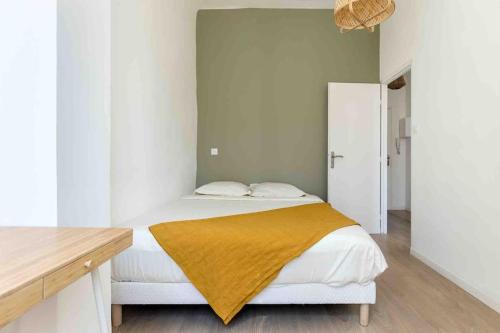 une chambre avec un lit avec une couverture jaune dessus dans l'établissement Appart cosy à 1’ du Cours Julien (Climatisé), à Marseille