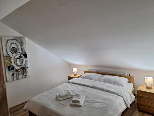 a bedroom with a bed with two towels on it at Apartmani Milosavljević in Kuršumlija
