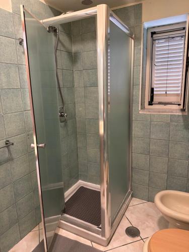 a shower with a glass door in a bathroom at In famiglia apartment and rooms for Pompei, Amalfi, Sorrento and Salerno in Sant'Egidio del Monte Albino