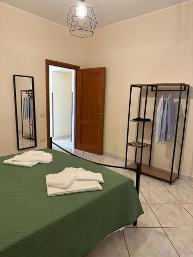 Habitación con cama verde y toallas. en in famiglia casa vacanze, en Sant'Egidio del Monte Albino