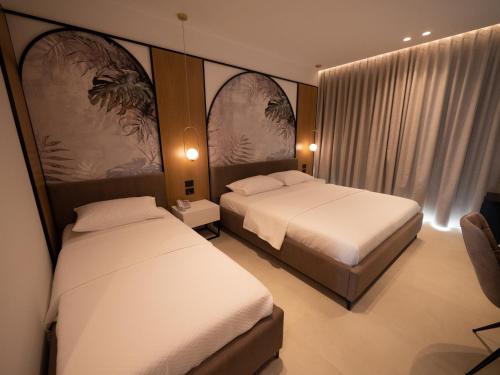 a hotel room with two beds and a chair at Colosseum Hotel in Ksamil