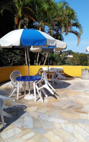 a table and chairs and an umbrella on a patio at Residencia Pereira in Serra Negra