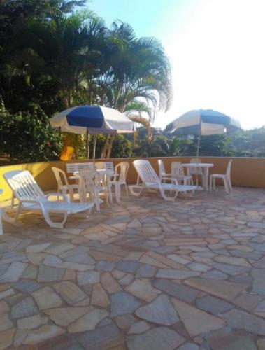 a group of chairs and umbrellas on a patio at Residencia Pereira in Serra Negra