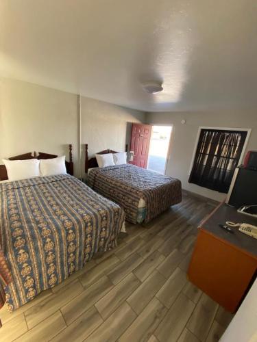 um quarto de hotel com duas camas e uma secretária em Ranger Motel em El Reno