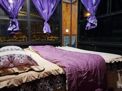 uma cama num quarto com cortinas roxas em Royal Belum Mystical em Gerik