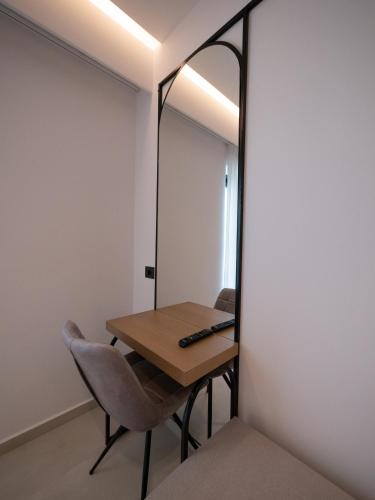 a mirror in a room with a table and a chair at Colosseum Hotel in Ksamil