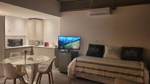 a bedroom with a bed and a table and a kitchen at La Belle San Isidro Lofts - Loft Lavandas y Loft Lilas in San Isidro