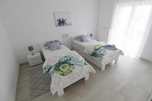 two beds in a room with white walls at Apartments with a parking space Umag - 21460 in Umag