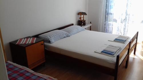 sypialnia z dużym białym łóżkiem i stołem w obiekcie Apartments and rooms by the sea Pirovac, Sibenik - 21487 w mieście Pirovac