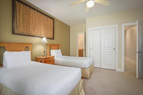 a hotel room with two beds and a ceiling fan at Aston At Poipu Kai in Koloa