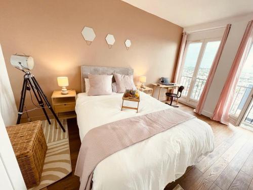 ein Schlafzimmer mit einem großen Bett mit einer Kamera in der Unterkunft Ciel de Paris : Vue Tour Eiffel in Choisy-le-Roi