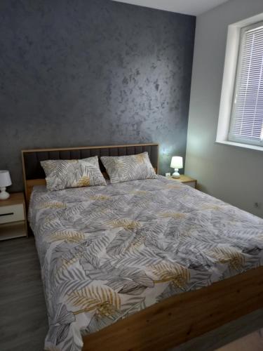 a large bed in a bedroom with two lamps at Silver Lake Apartments in Veliko Gradište