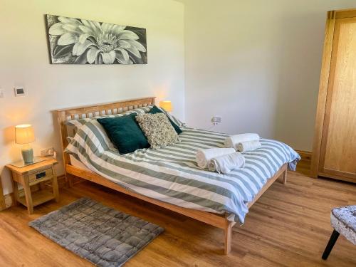 - une chambre avec un grand lit et des serviettes dans l'établissement Aylesbury Lodge, à Halstead