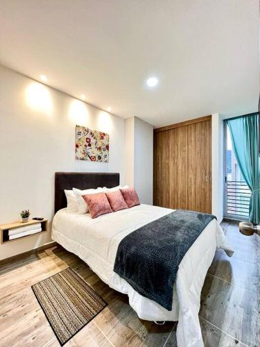 een slaapkamer met een groot bed en een raam bij 401S Refugio Acogedor Moderno Para Ti en Ibague in Bogota