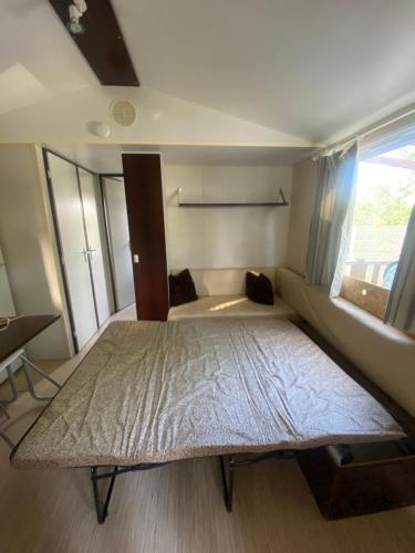 a bedroom with a large bed and a couch at Séjour inoubliable en Provence, camping 3 étoiles in La Roque-dʼAnthéron