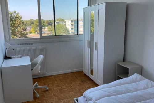 Schlafzimmer mit einem Bett, einem Schreibtisch und einem Fenster in der Unterkunft 30 min de Paris Grand appartement neuf et lumineux in Cergy