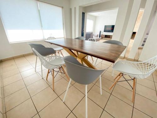 una sala da pranzo con tavolo e sedie in legno di Spacious home in El Monasterio 7 min from Plaza Altozano a Morelia