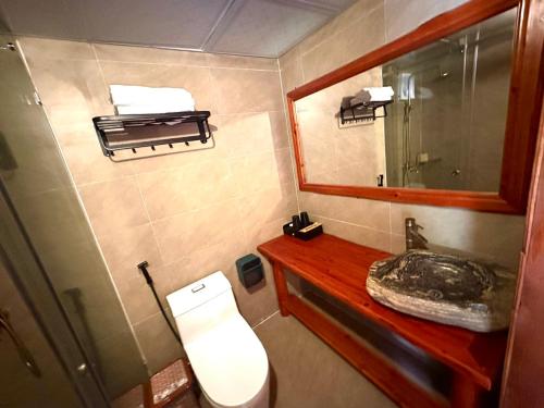 uma pequena casa de banho com WC e espelho em Bac Ha Lodge Retreat em Bac Hà