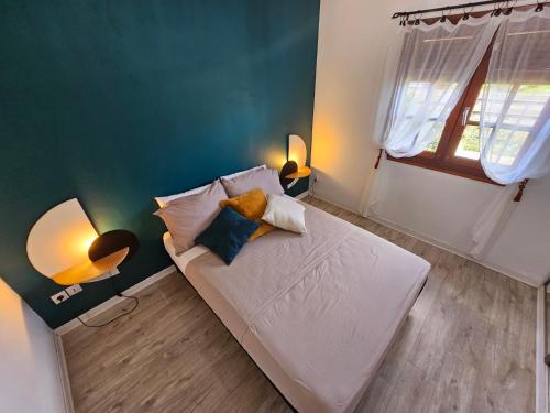 Un dormitorio con una cama blanca con almohadas y una ventana en Villa TYNO en Le Moule