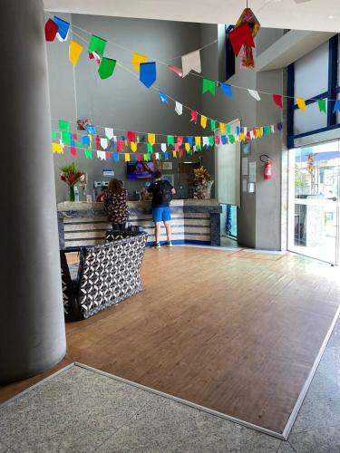 a person standing in a room with flags on the ceiling at Flat Beira Mar Piedade in Recife
