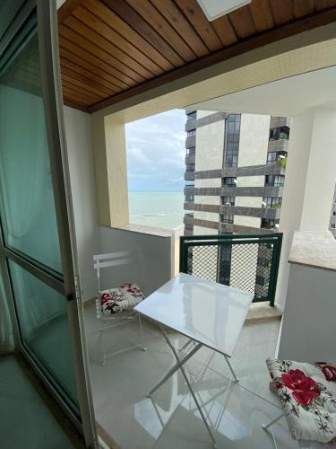 a balcony with a white table and a view of the ocean at Flat Beira Mar Piedade in Recife