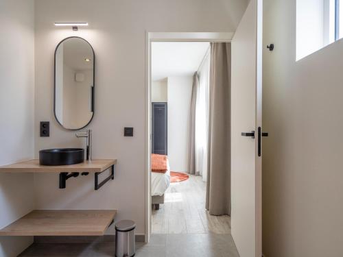 W łazience znajduje się umywalka i lustro. w obiekcie Luxury holiday home in Kortrijk with wellness and heated pool w mieście Kortrijk