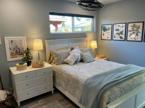 a bedroom with a bed with a dresser and a window at Encanto Cactus Flower Casita in Phoenix