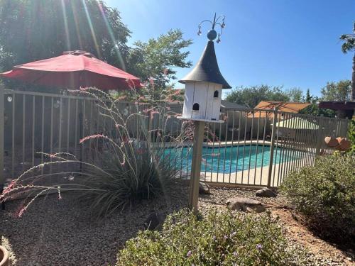 a bird house in a garden next to a pool at Encanto Cactus Flower Casita in Phoenix