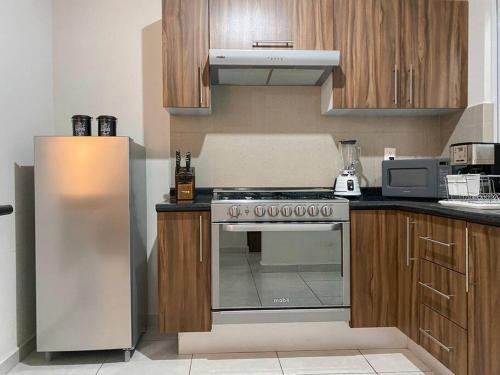 a kitchen with a stove and a refrigerator at Modern gated townhouse 5 min from Plaza Altozano in Morelia