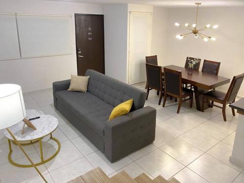 a living room with a couch and a dining room at Modern gated townhouse 5 min from Plaza Altozano in Morelia
