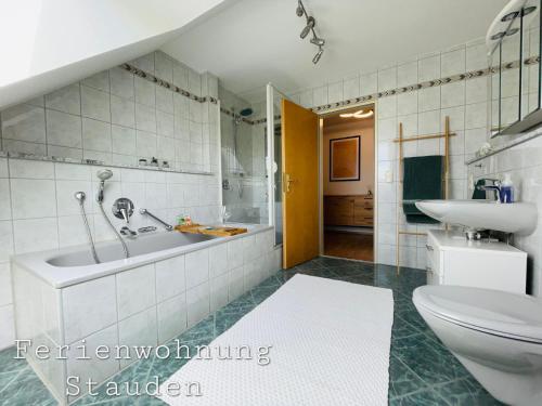 uma casa de banho com uma banheira, um lavatório e um WC. em Sonnige Ferienwohnung im Unterallgäu em Ettringen